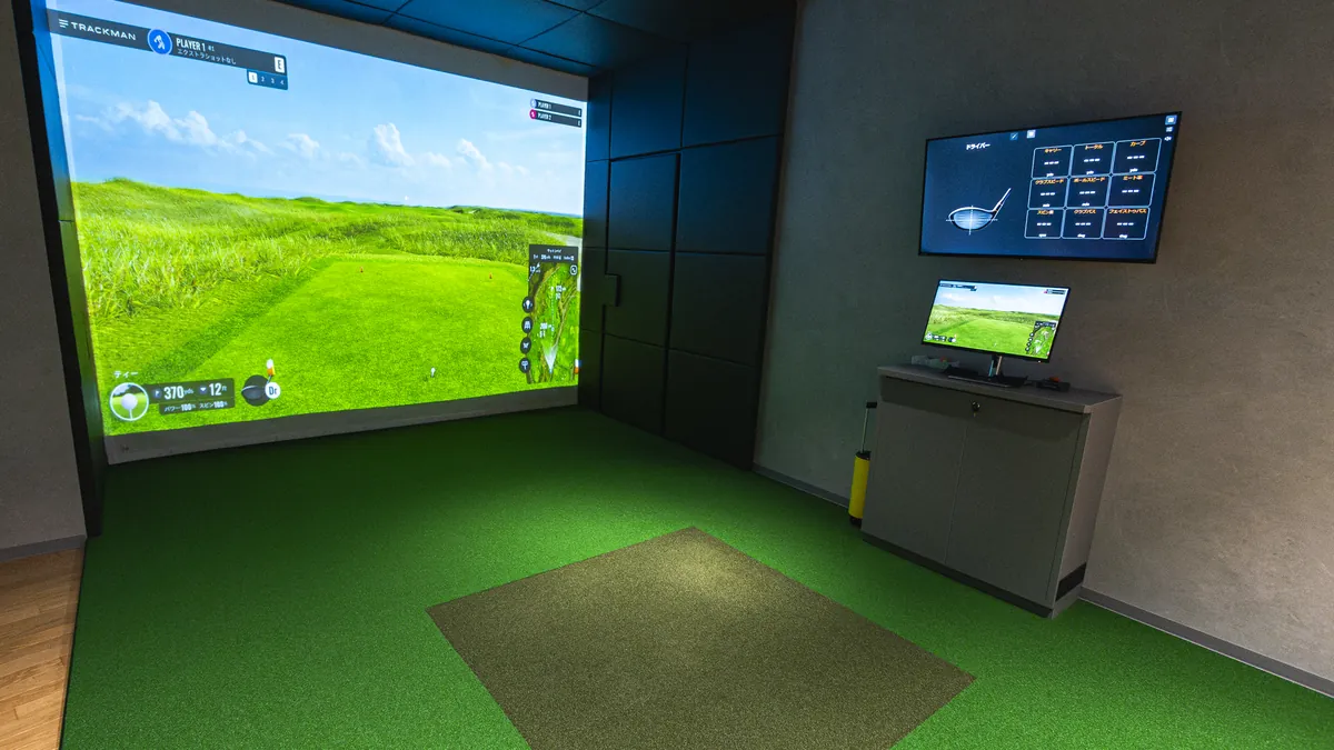 T-One Golf Studioの打席 大きなスクリーンにゴルフコースが映し出されている
