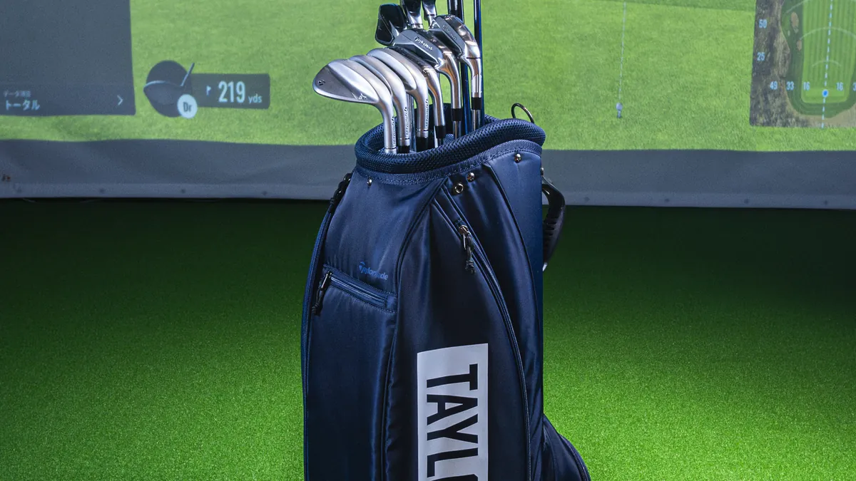 T-One Golf Studioのレンタルクラブが入ったキャディバッグとTrackManのスクリーン