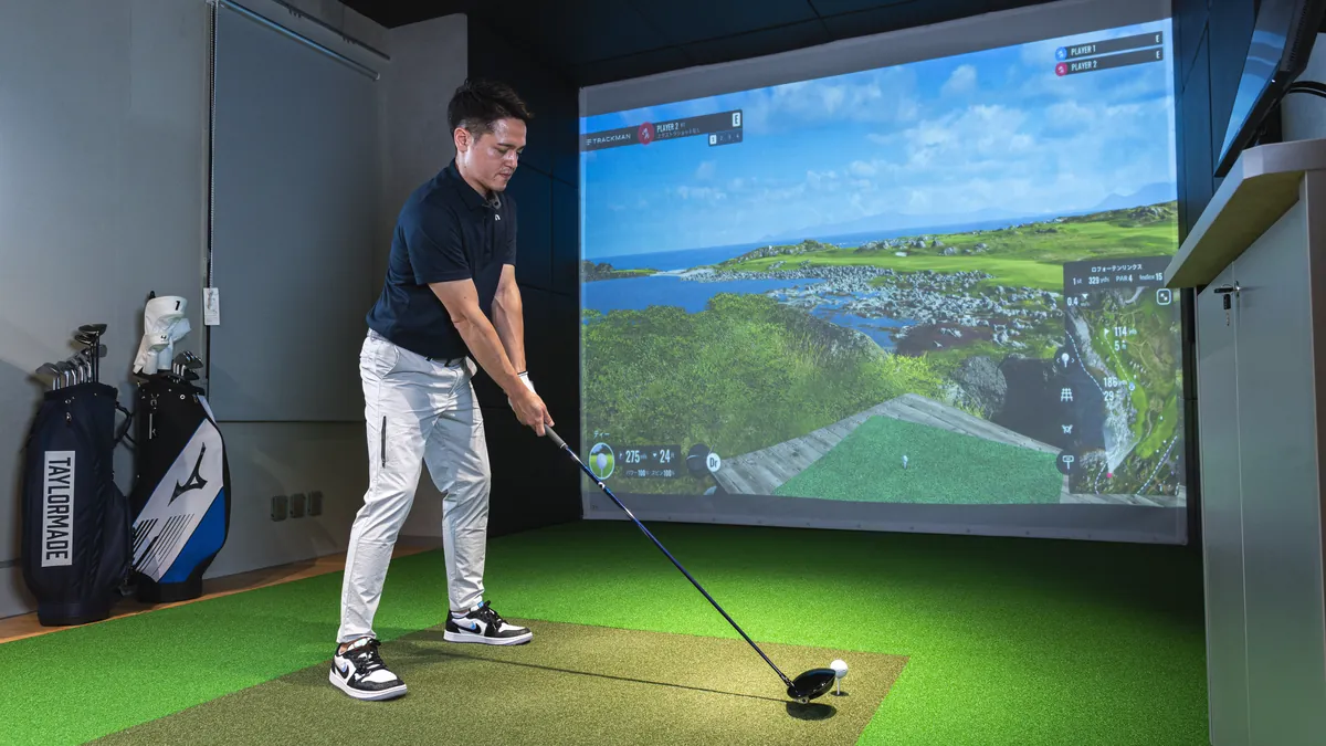T-One Golf Studioの打席でドライバーを構えるゴルファー