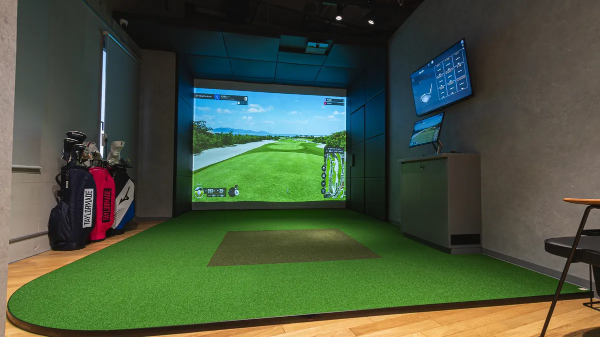 T-One Golf Studioの打席 TrackMan iOのスクリーンと緑の打席マット