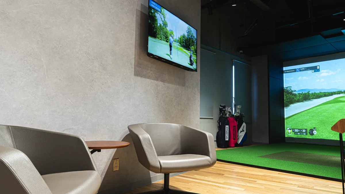T-One Golf Studioの休憩スペース いすとテレビ、奥に打席