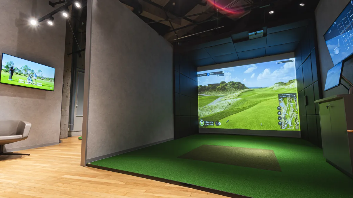 照明に照らされたT-One Golf Studioの室内と打席