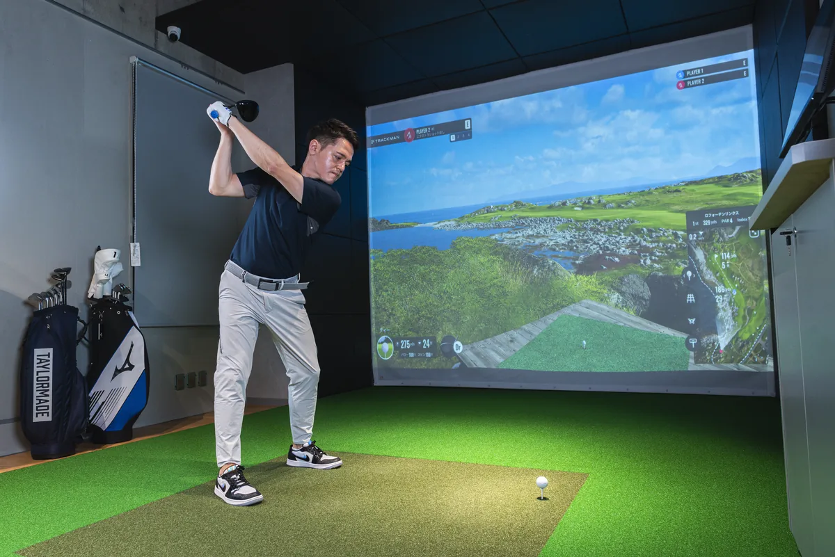 T-One Golf StudioのTrackMan打席でドライバーを振るゴルファー